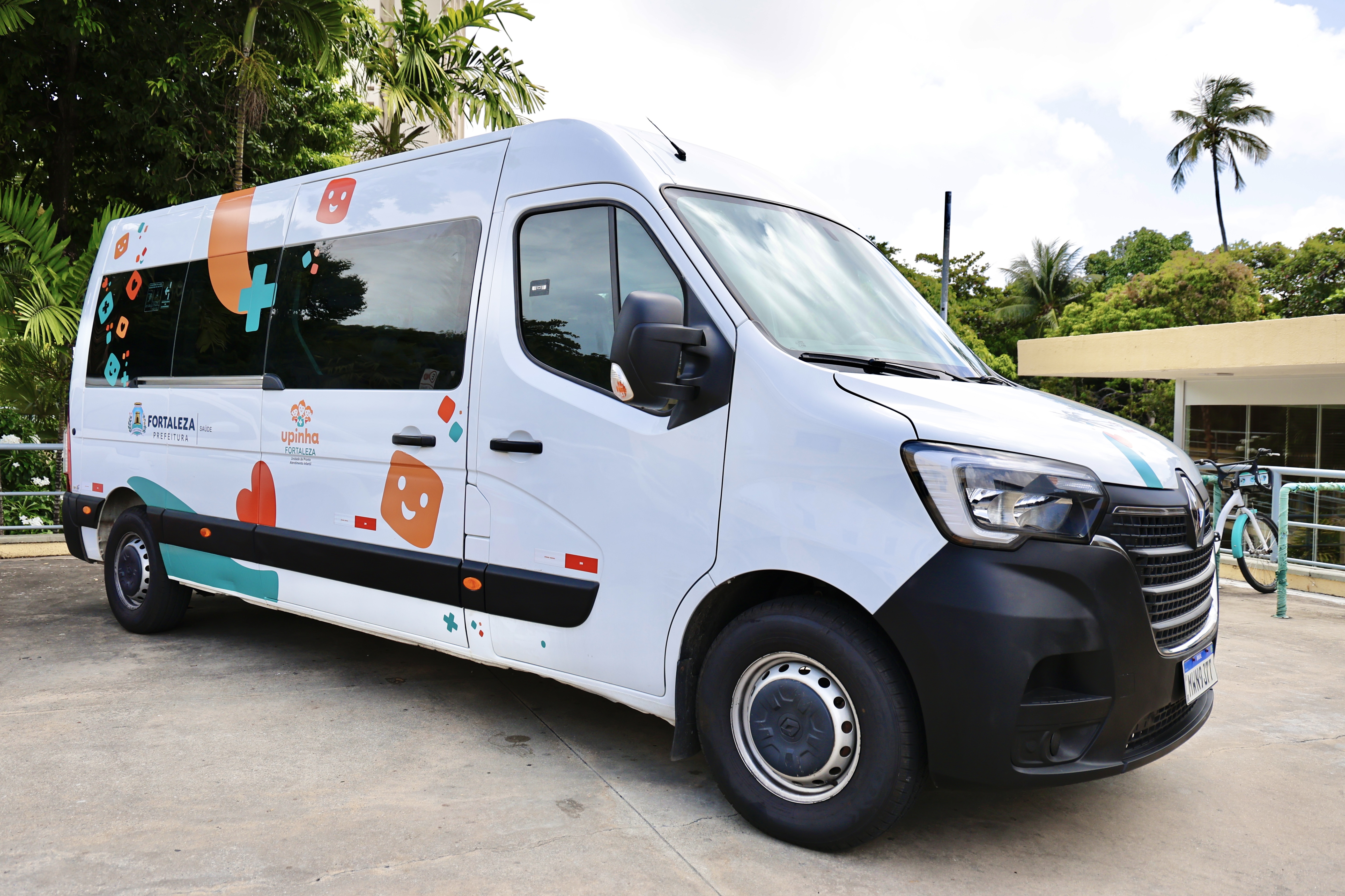 Veículo do tipo van branco, adesivado com o nome Upinha